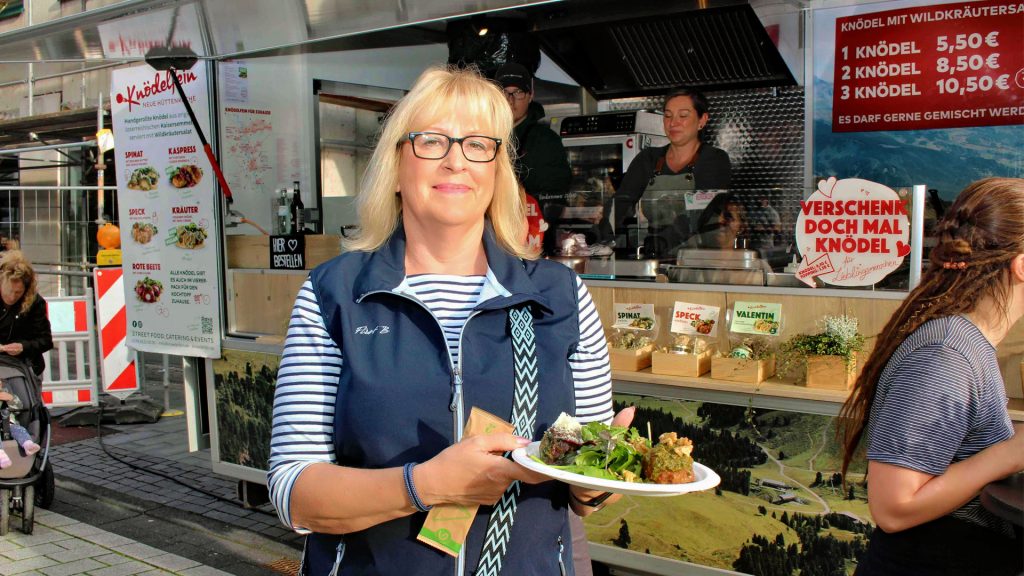 Frau mit Teller an einem Essensstand bei A la Carte