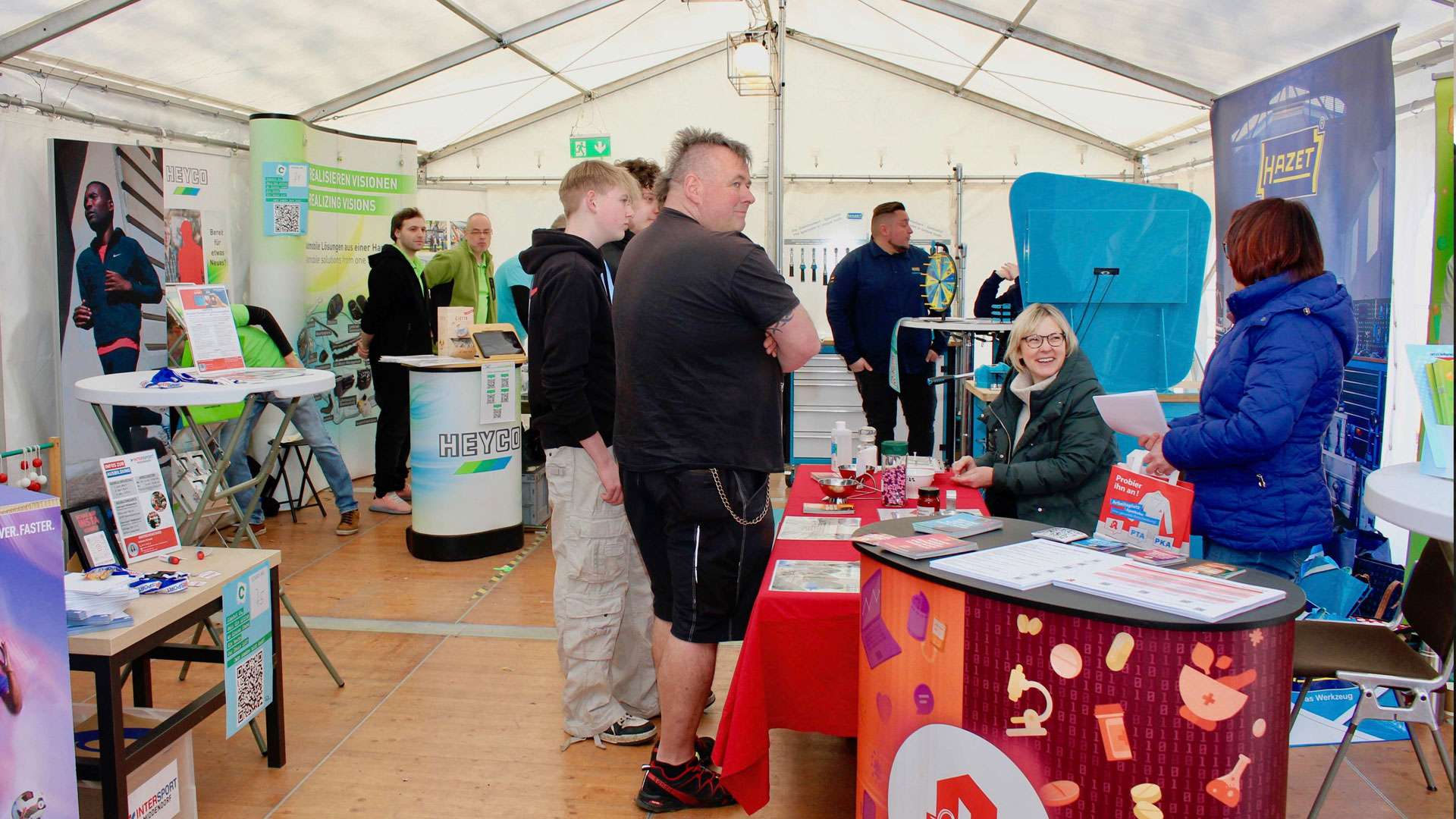 Besucher an einem Stand im Zelt bei Connect 2025
