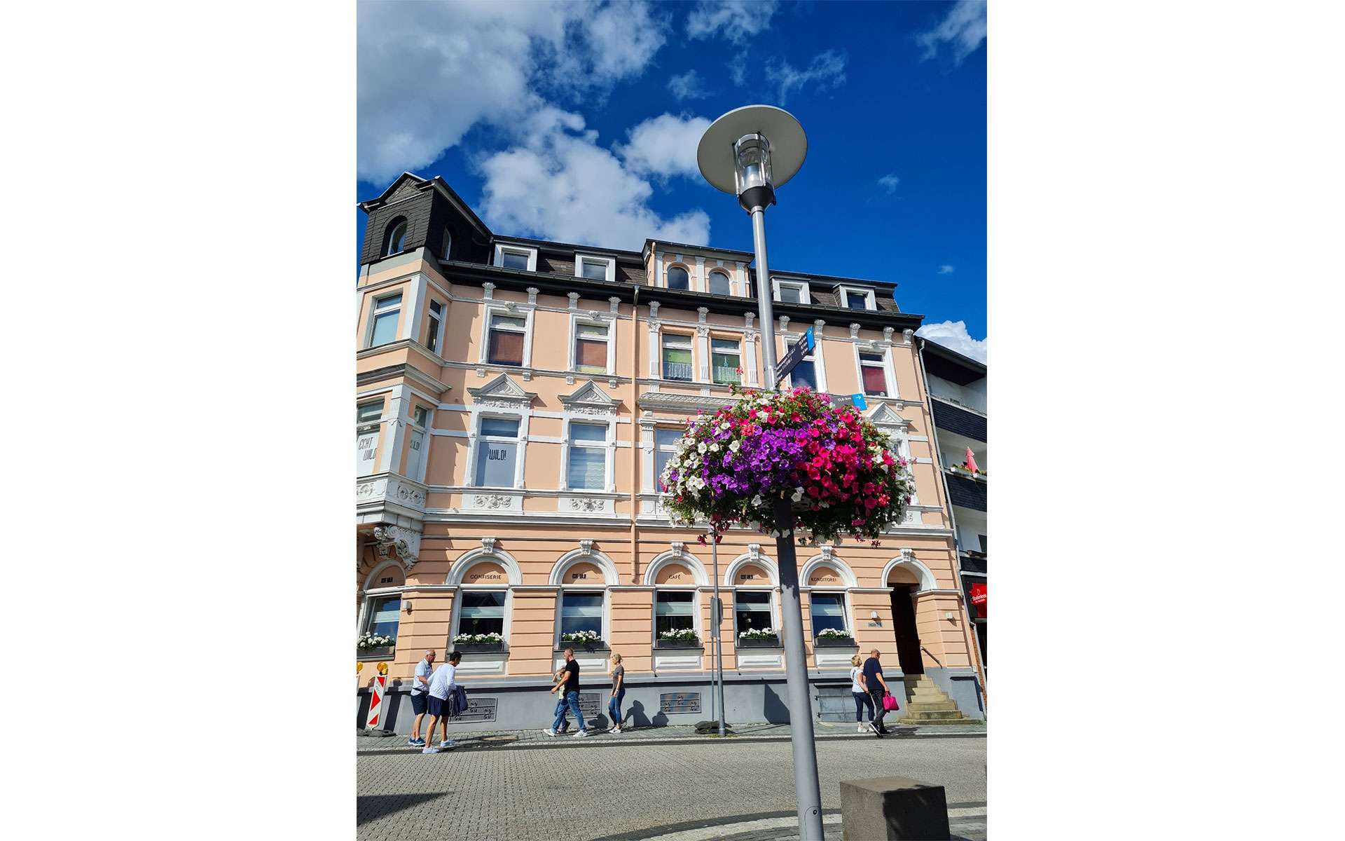 Blumenampel vor einem hellen Altbau