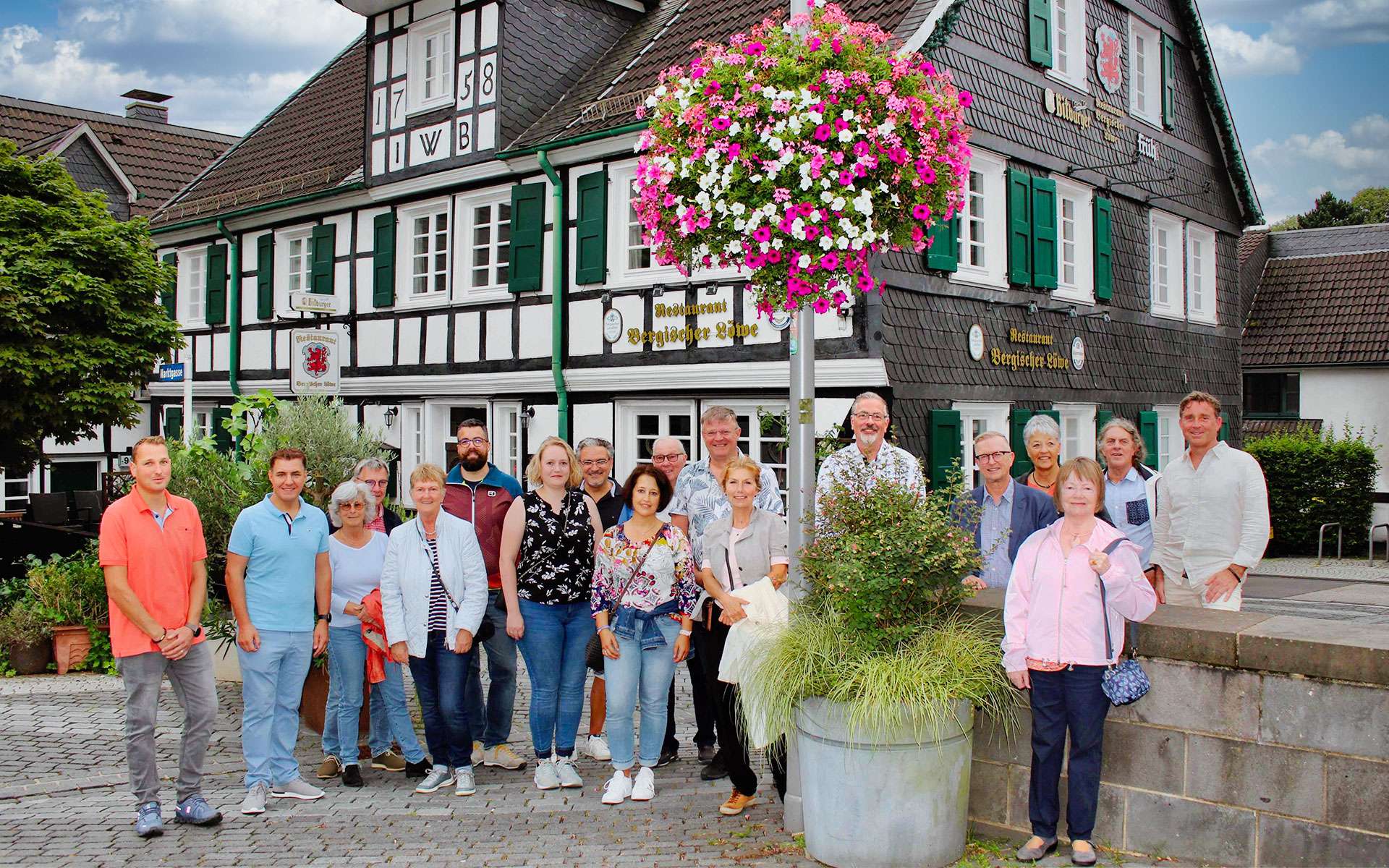 Gruppenfoto zur Blumenampel-Aktion vor einem Fachwerkhaus