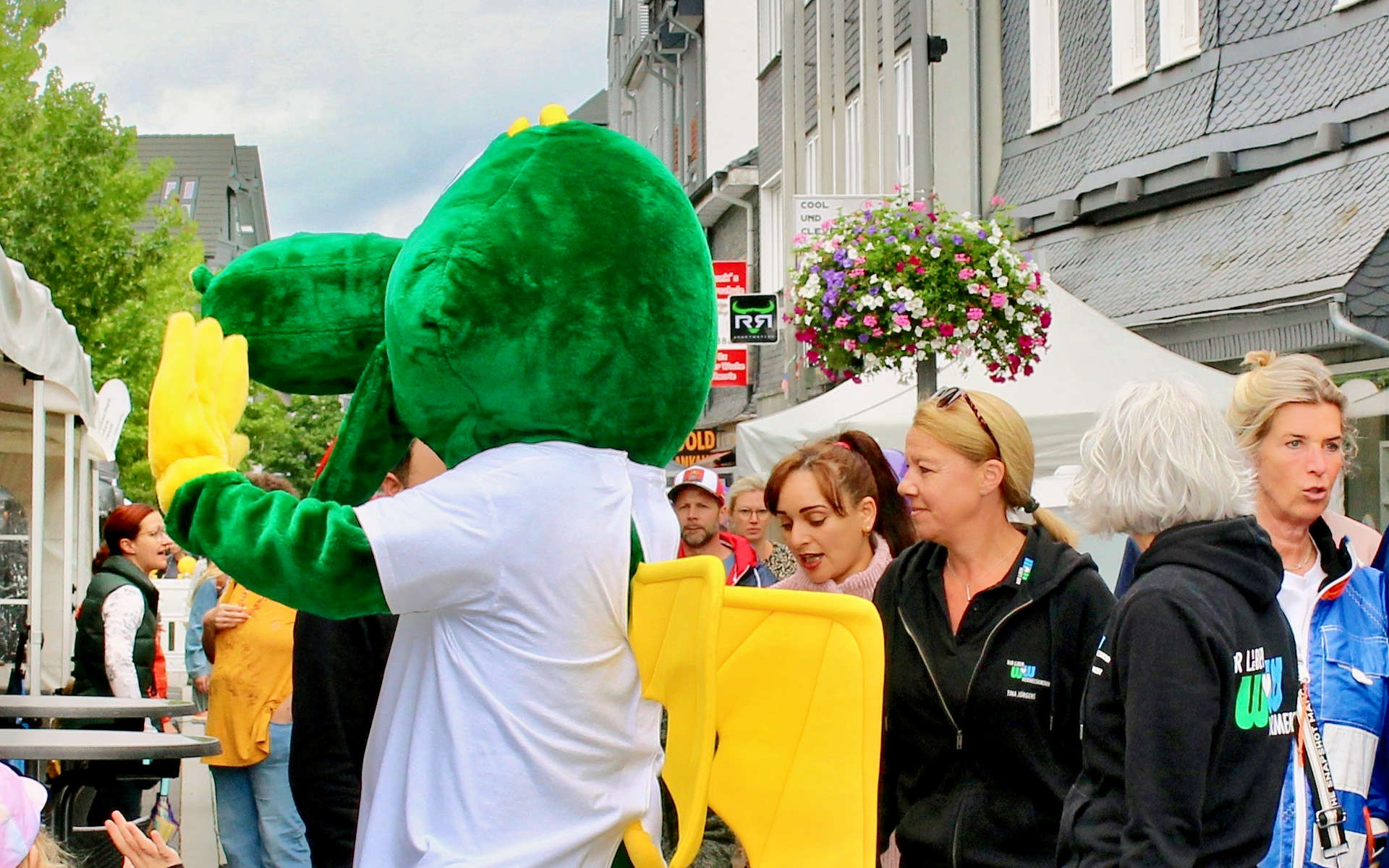 Maskottchen Dellouga begrüßt Besucherinnen am Kirmessonntag