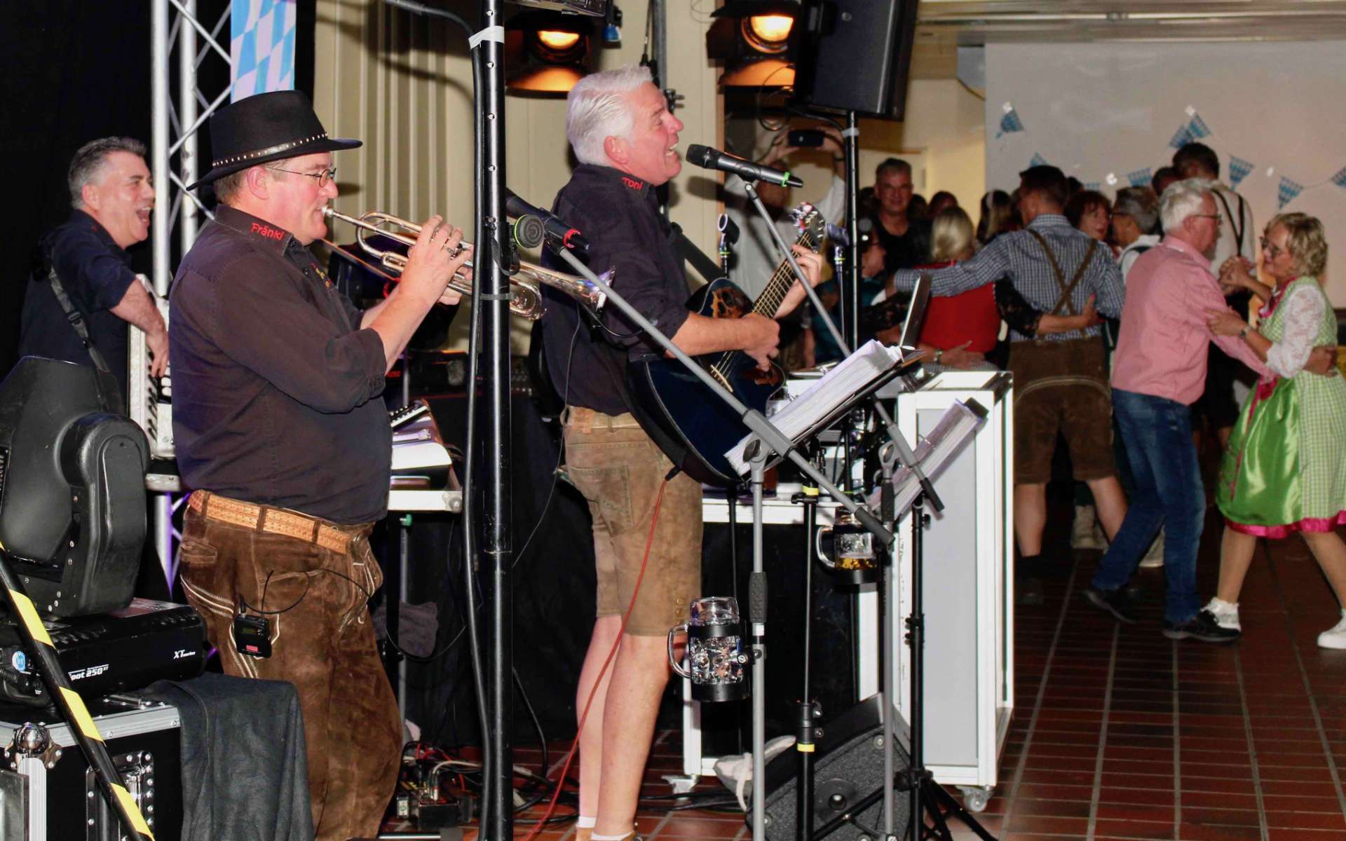 Band in Tracht spielt beim Oktoberfest, Gäste tanzen