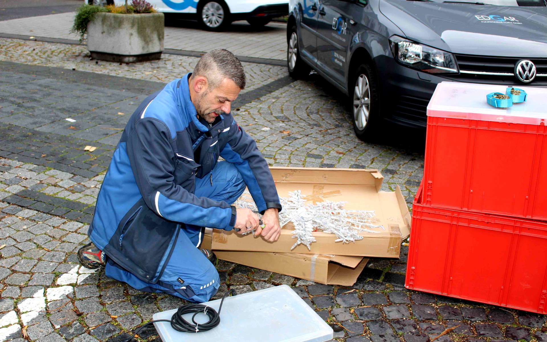 Helfer bereitet Lichterketten für die Weihnachtsbeleuchtung vor