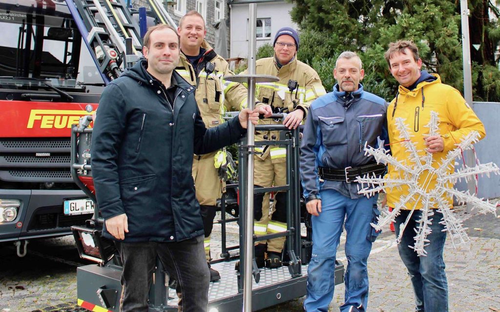 Helfer und Feuerwehr beim Aufhängen der Weihnachtsbeleuchtung