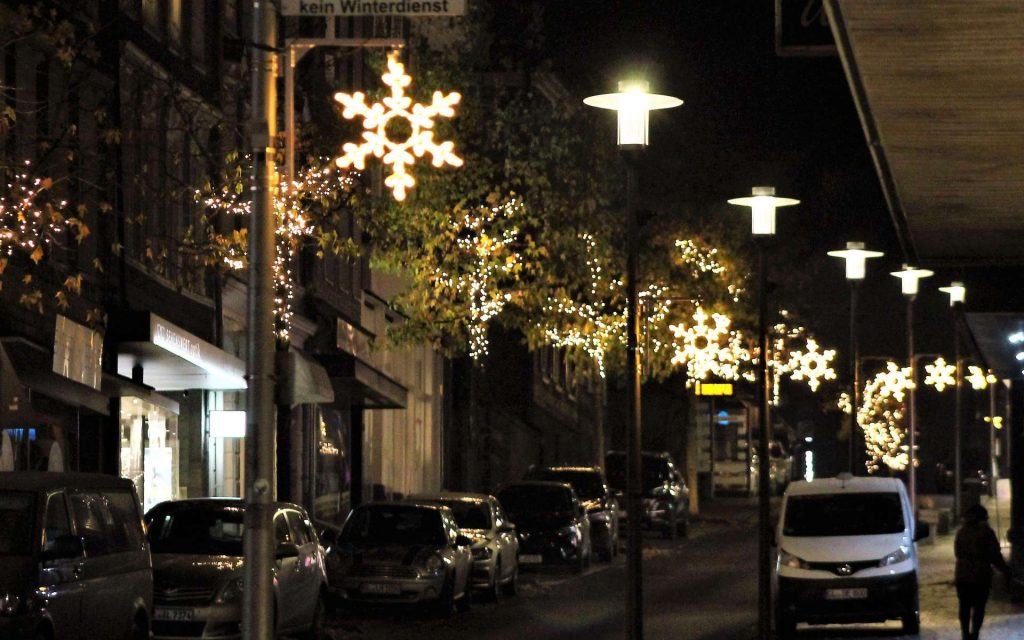 Weihnachtsbeleuchtung mit Lichtsternen in einer Straße bei Nacht