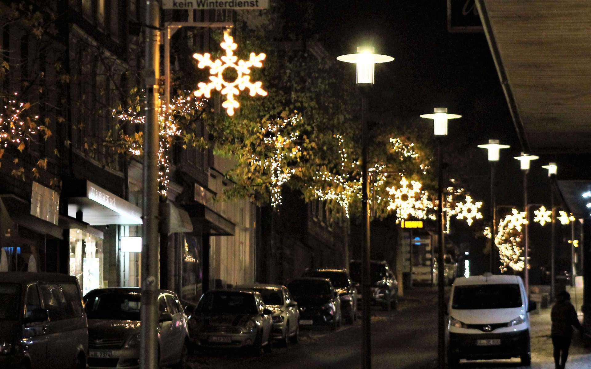 Weihnachtsbeleuchtung mit Lichtsternen in einer Straße bei Nacht